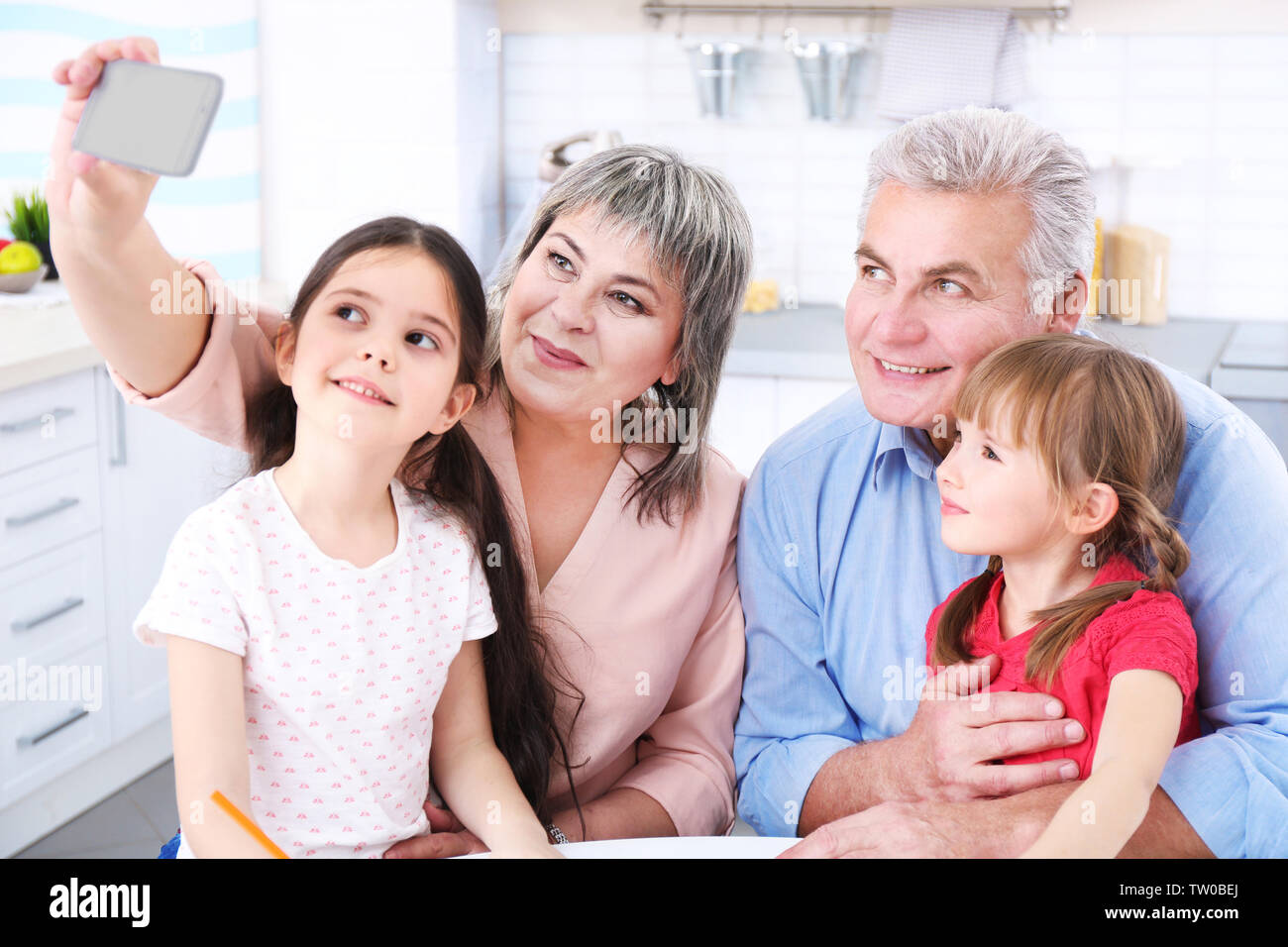 Grand parents avec peu de filles prenant selfies Banque D'Images