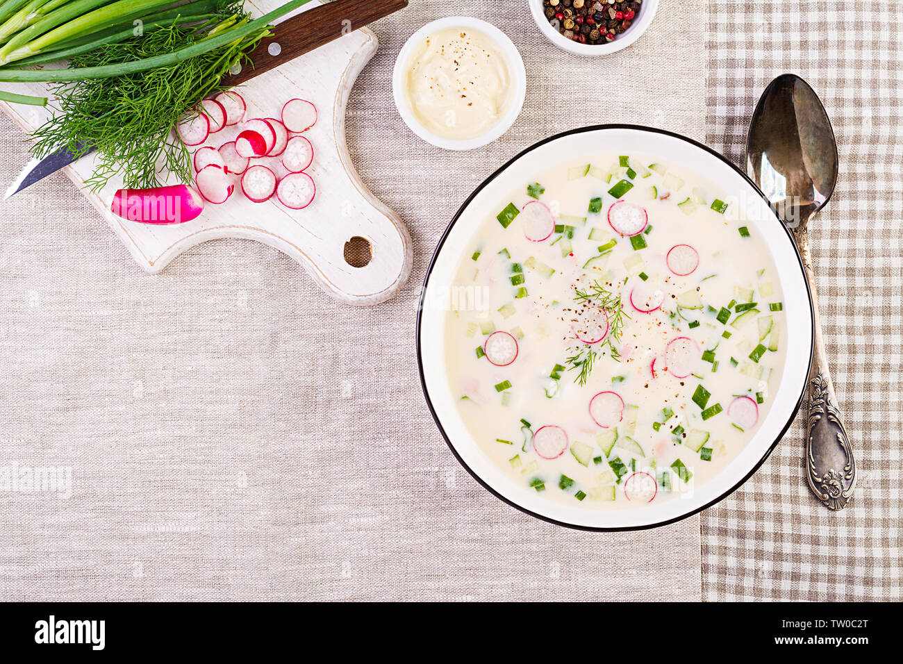 Soupe froide de concombres, radis, pomme de terre et des saucisses avec du yogourt dans un bol. La cuisine russe traditionnelle - okroshka. Soupe froide d'été. Vue d'en haut. Fl Banque D'Images