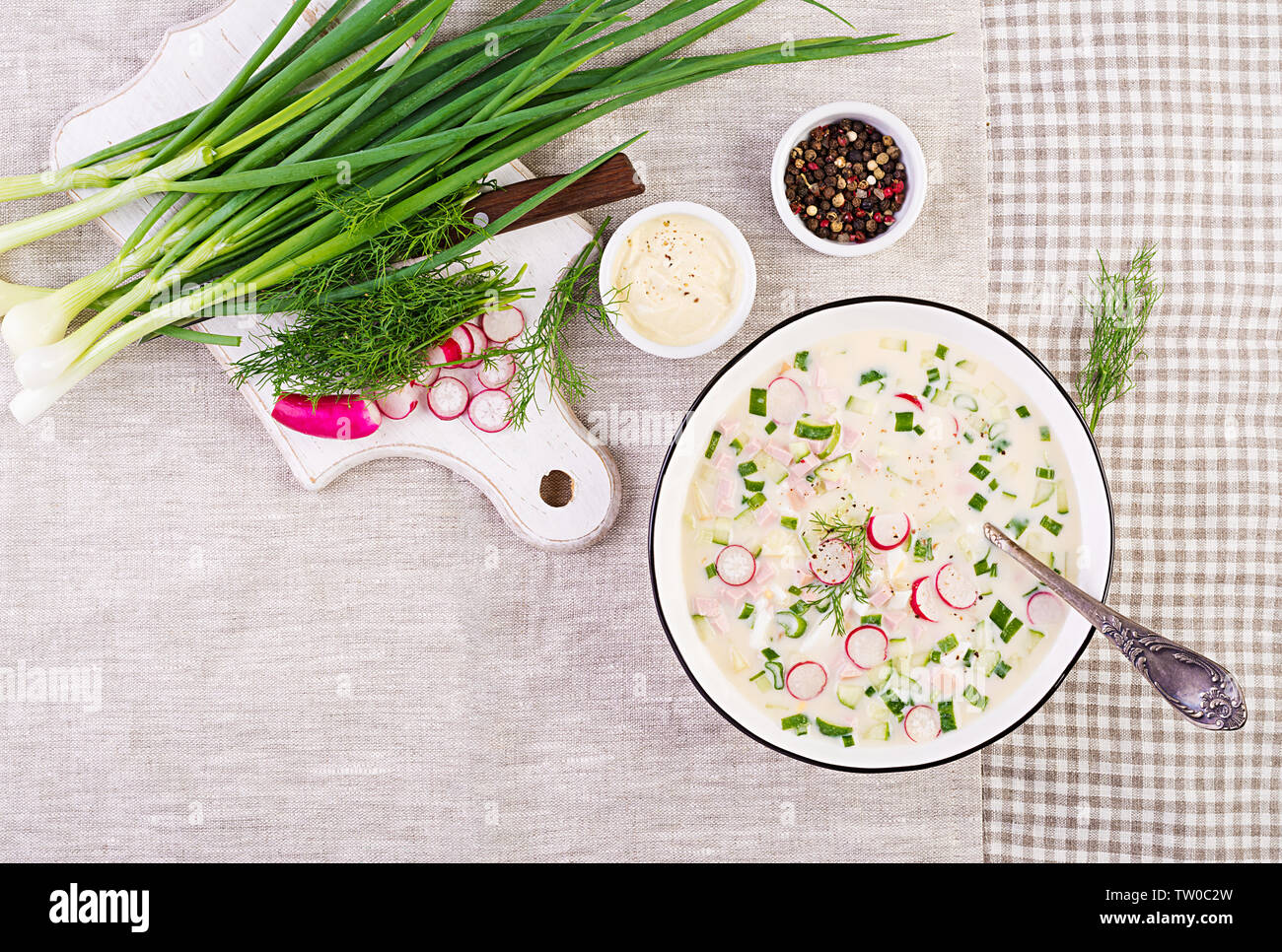 Soupe froide de concombres, radis, pomme de terre et des saucisses avec du yogourt dans un bol. La cuisine russe traditionnelle - okroshka. Soupe froide d'été. Vue d'en haut. Fl Banque D'Images