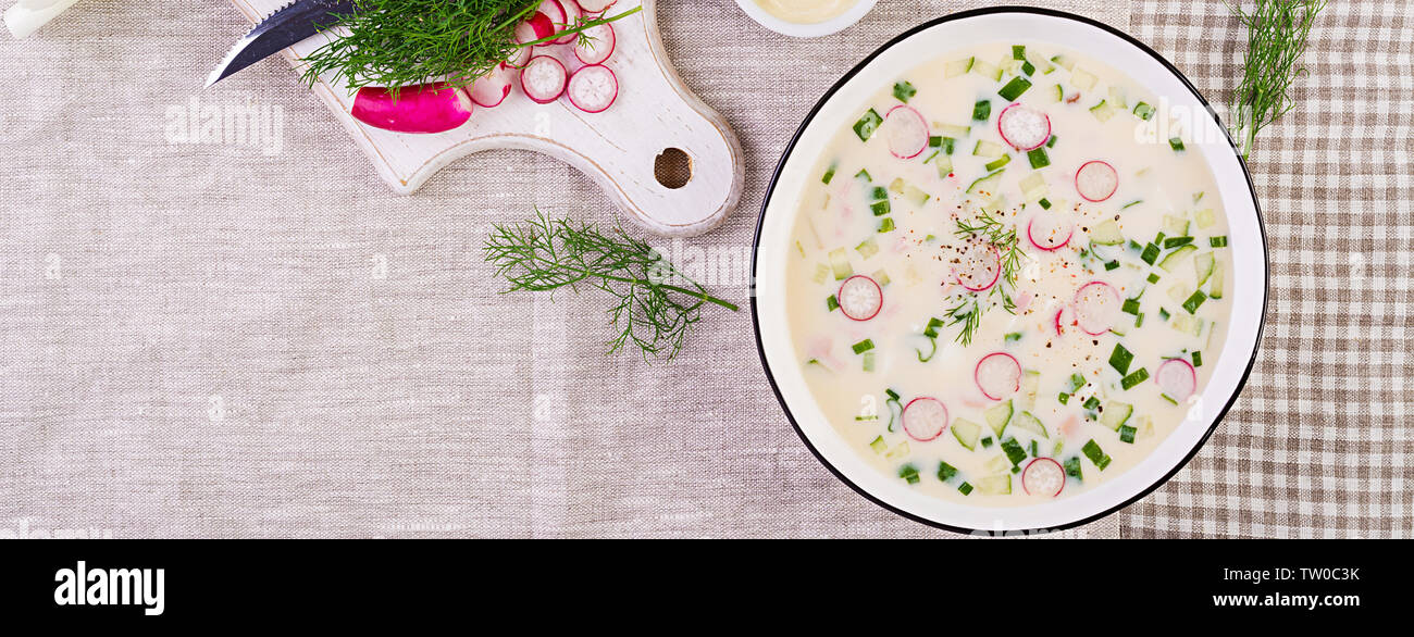Soupe froide de concombres, radis, pomme de terre et des saucisses avec du yogourt dans un bol. La cuisine russe traditionnelle - okroshka. Soupe froide d'été. Vue d'en haut. Ba Banque D'Images