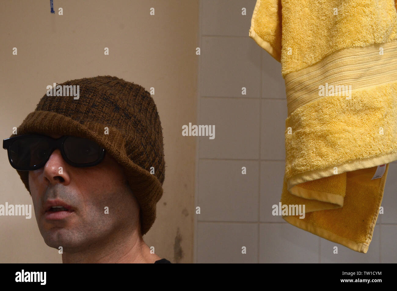 Self Portrait de l'homme avec des lunettes et chapeau brun dans les toilettes Banque D'Images