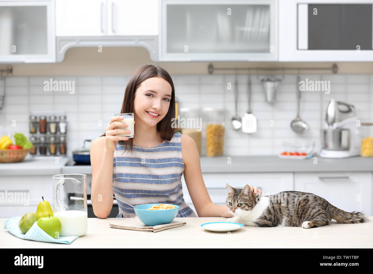 Matin de belle jeune femme et de chat dans la cuisine Banque D'Images