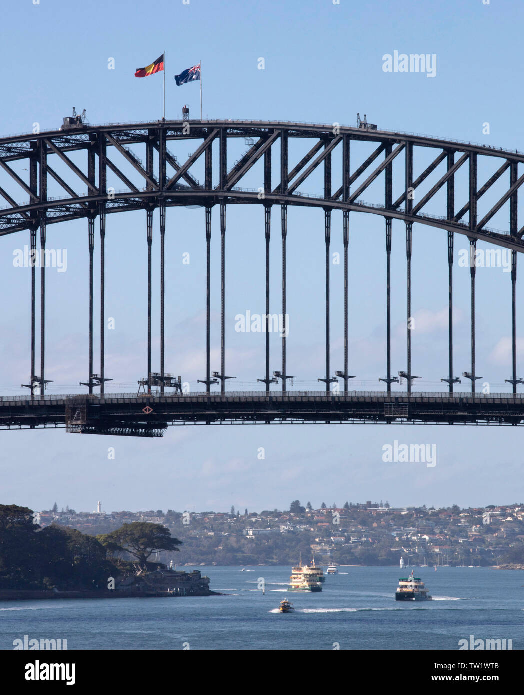 Détail de Sydney Harbour Bridge avec drapeau national et du pavillon autochtone. Jardins de l'Admiralty House sont situés en bas à gauche. D'exploitation des bateaux Banque D'Images
