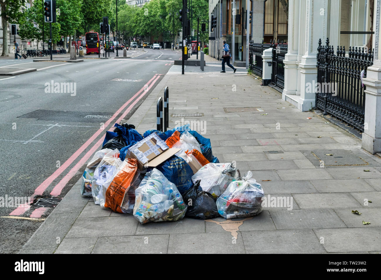 Londres, Royaume-Uni - 30 mai 2019 : déchets entassés sur le côté d'une rue de Londres. Banque D'Images