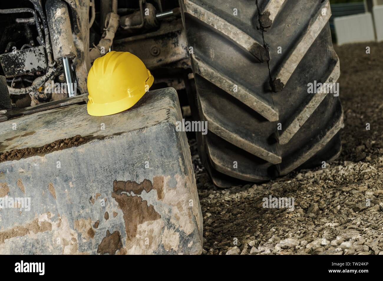 Concept de sécurité industrielle avec un casque jaune et le matériel de construction lourde. Banque D'Images
