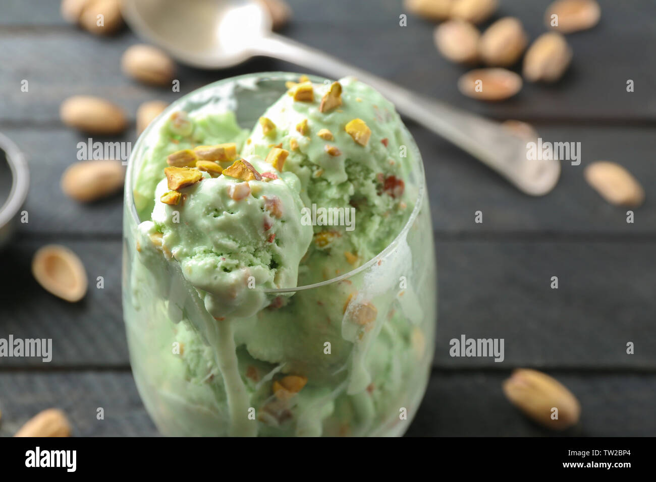 Avec verre fusion délicieuse glace pistache-crème sur fond de bois noir Banque D'Images