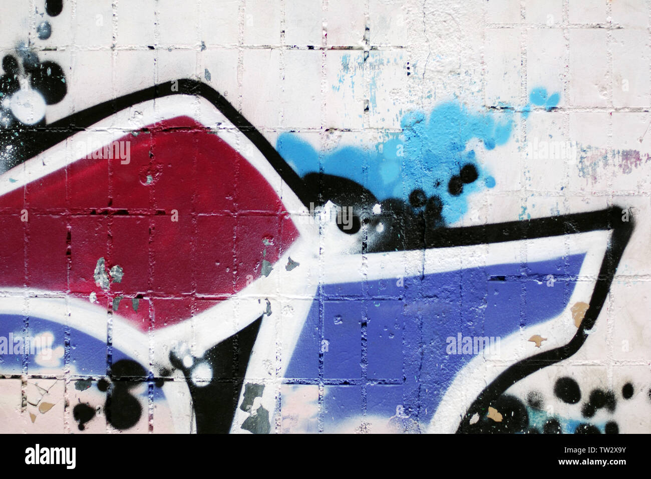 Mur en brique blanche avec le fragment de mur miteux graffiti colorés pour grungy urban background Banque D'Images