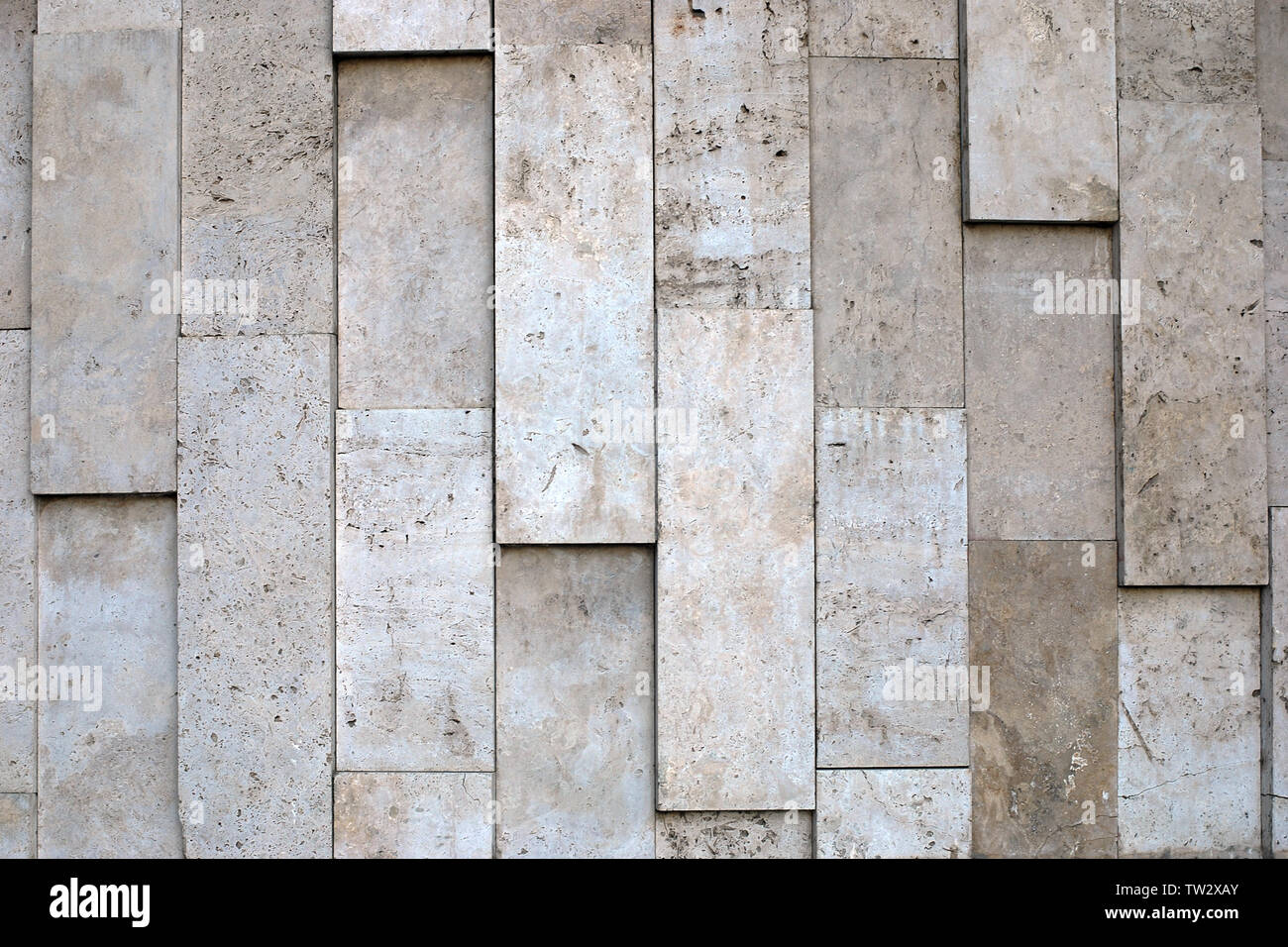 Mur en pierres naturelles de grand blocs verticaux de matière poreuse dans variété de beige. Banque D'Images