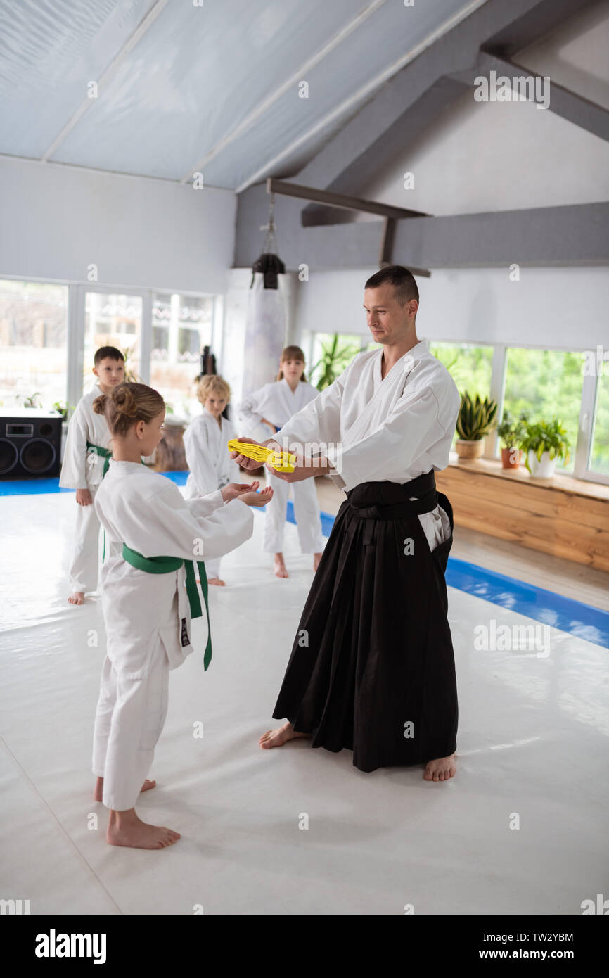 Courroie pour élève. Les jeunes formateurs aikido ceinture jaune donnant à  sa belle élève talentueux Photo Stock - Alamy