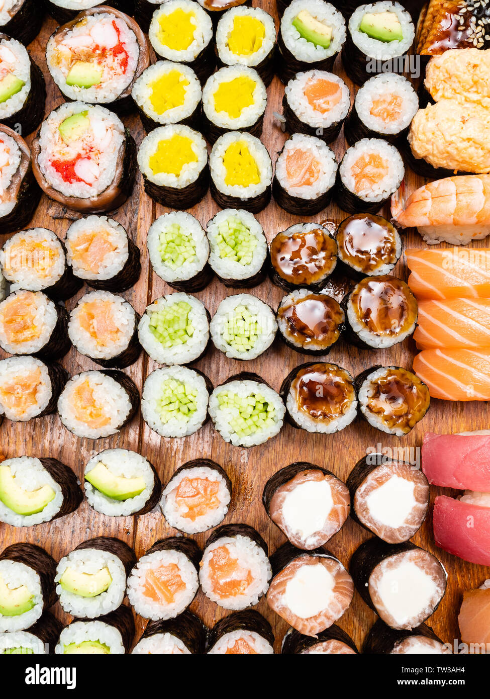 Vue de dessus d'un grand nombre de rouleaux de sushi et on wooden table Banque D'Images