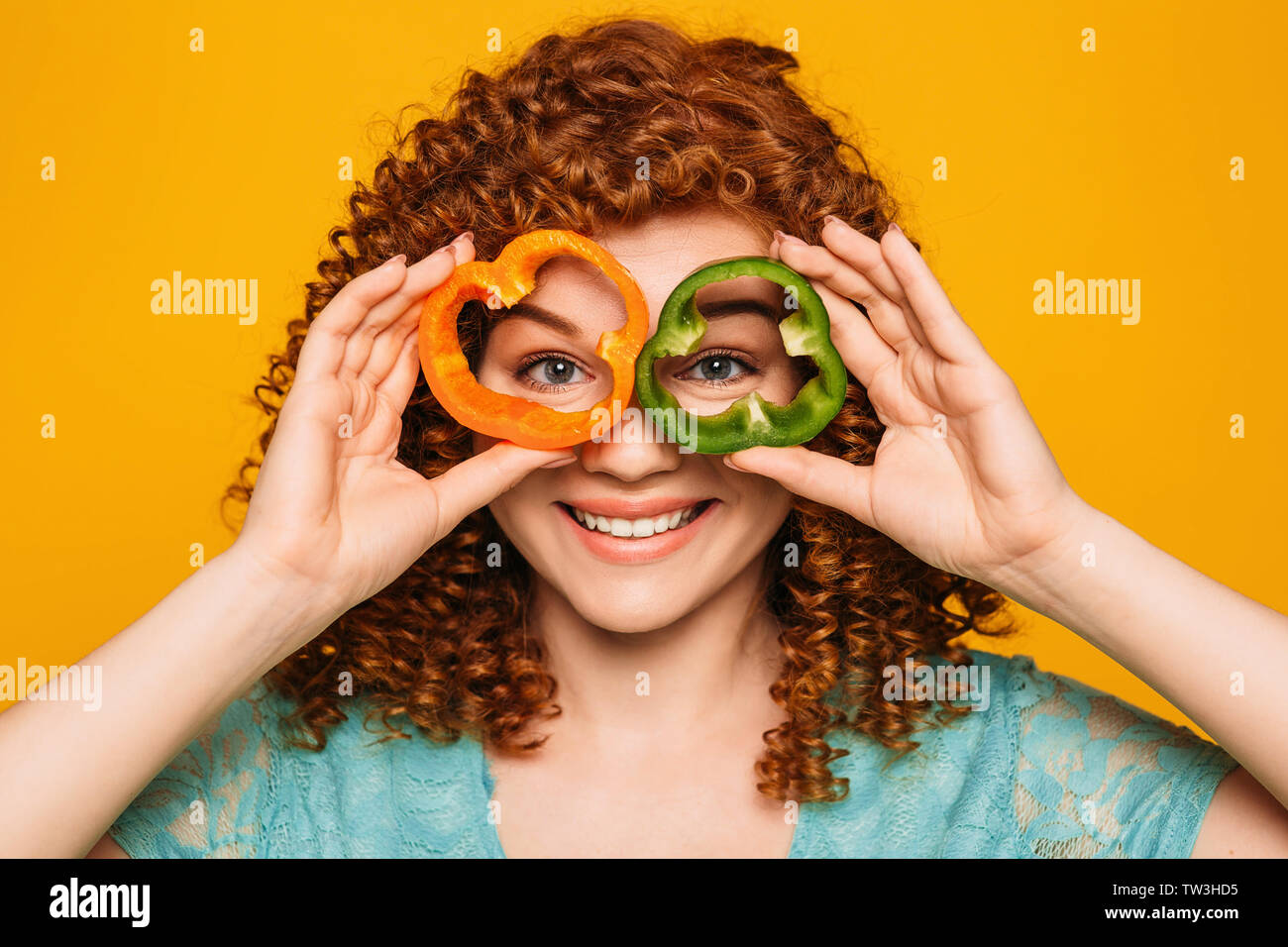 Curly haired woman holding eyeglasses essence poivre de près de ses yeux. Voir mieux et choisissez vos meilleures lunettes Banque D'Images