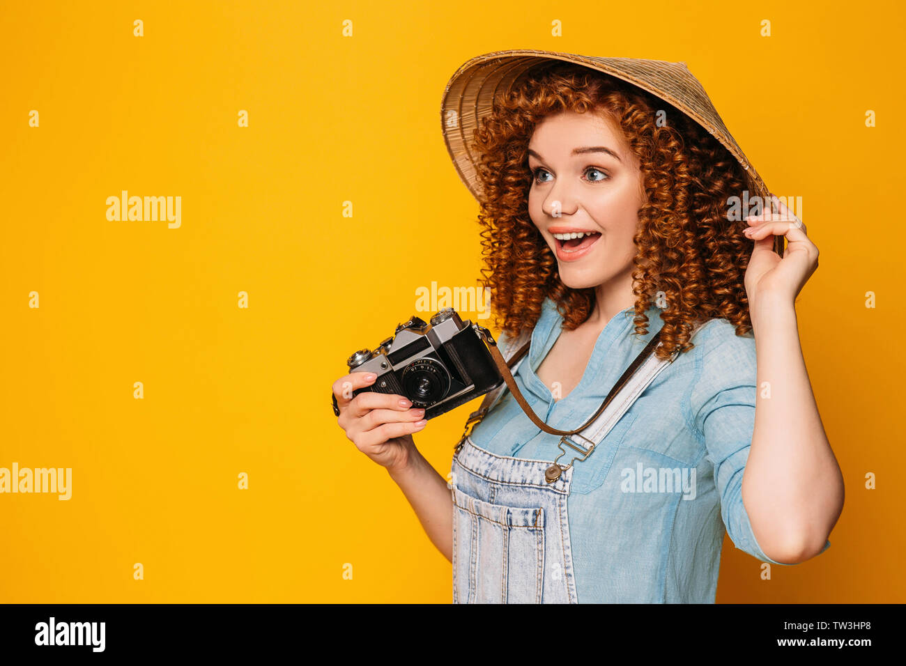 Femme de tourisme en chapeau de paille avec appareil photo visage surpris.meilleur disant wow Banque D'Images