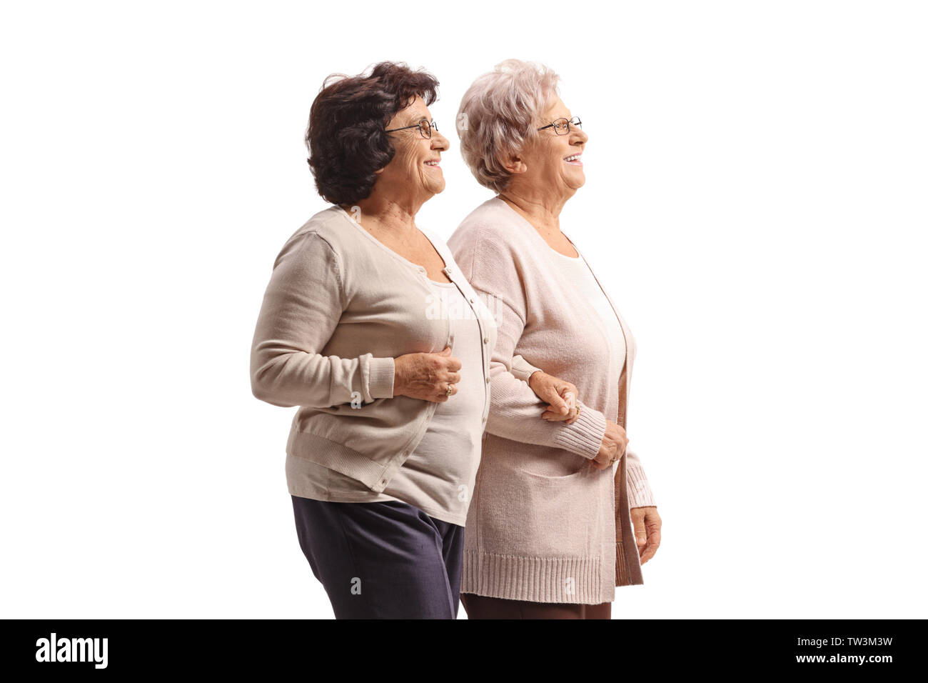 Deux femmes âgées marcher ensemble main dans la main isolé sur fond blanc Banque D'Images