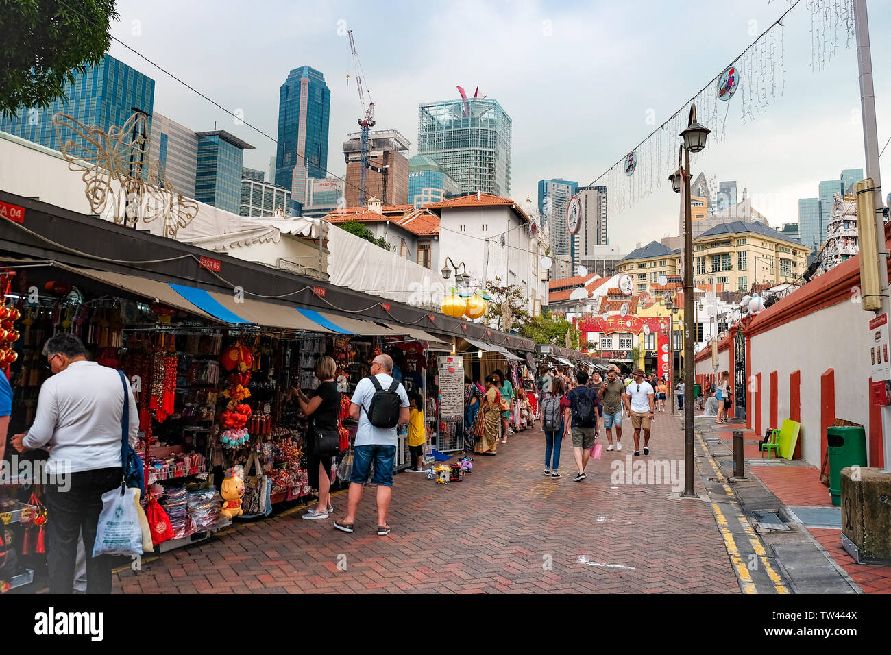 Vue générale du marché de Chinatown à Singapour en contraste avec les gratte-ciel du quartier des affaires sur une sombre journée humide avec des boutiques touristiques. Banque D'Images