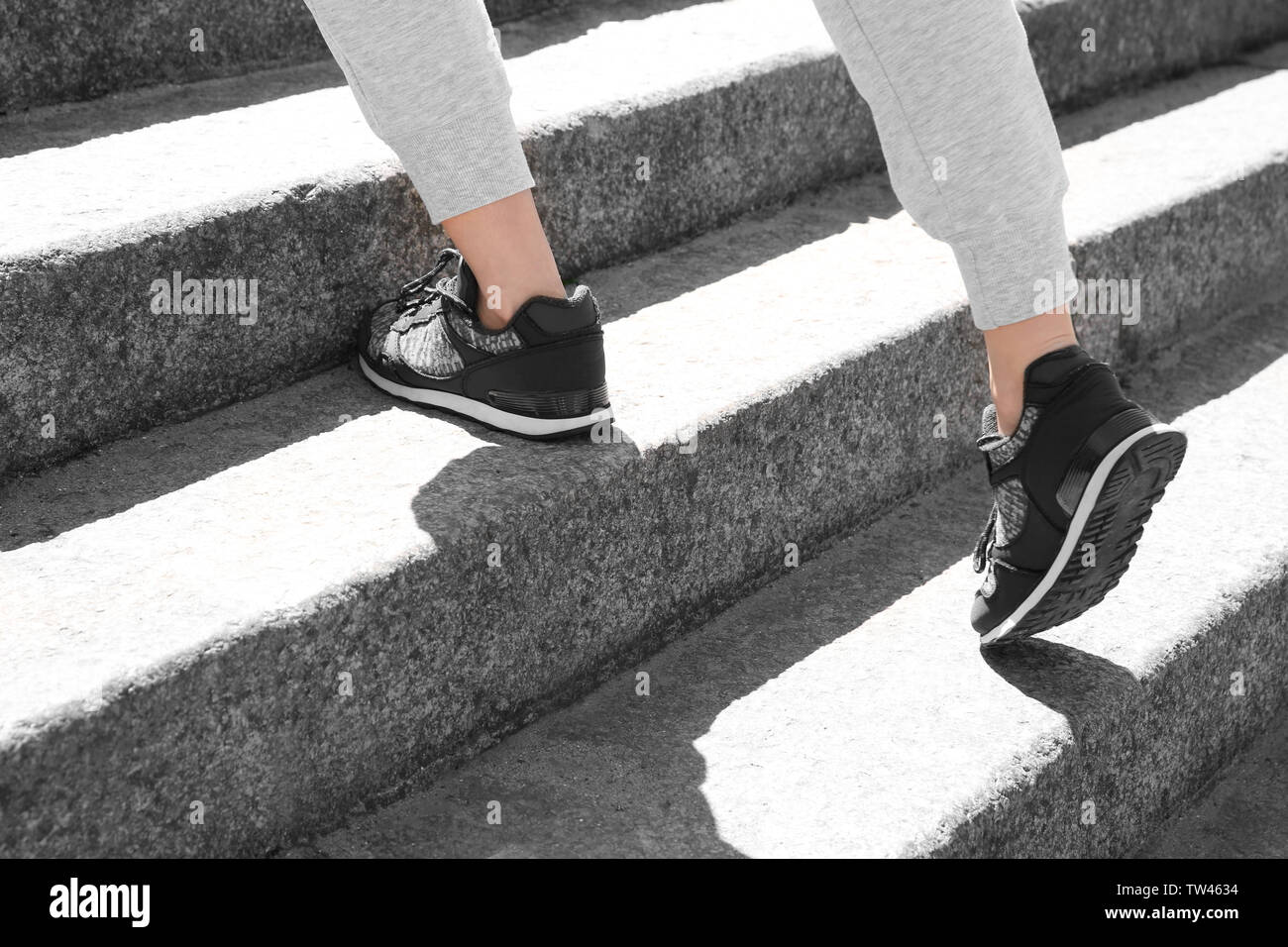 Femme sportive courir vers le haut des escaliers en pierre Banque D'Images