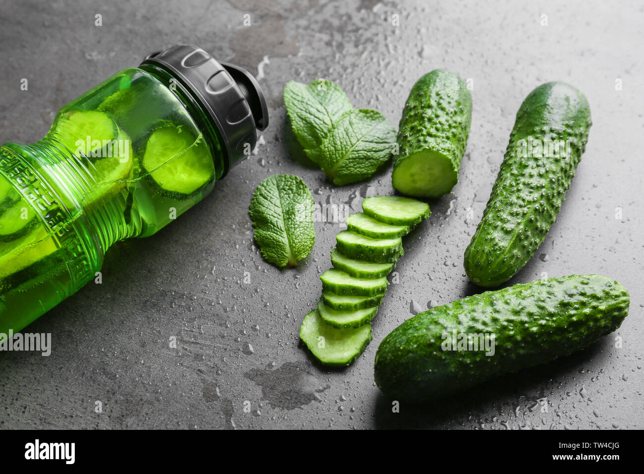 La composition avec bouteille de l'eau infusée sur fond gris Banque D'Images