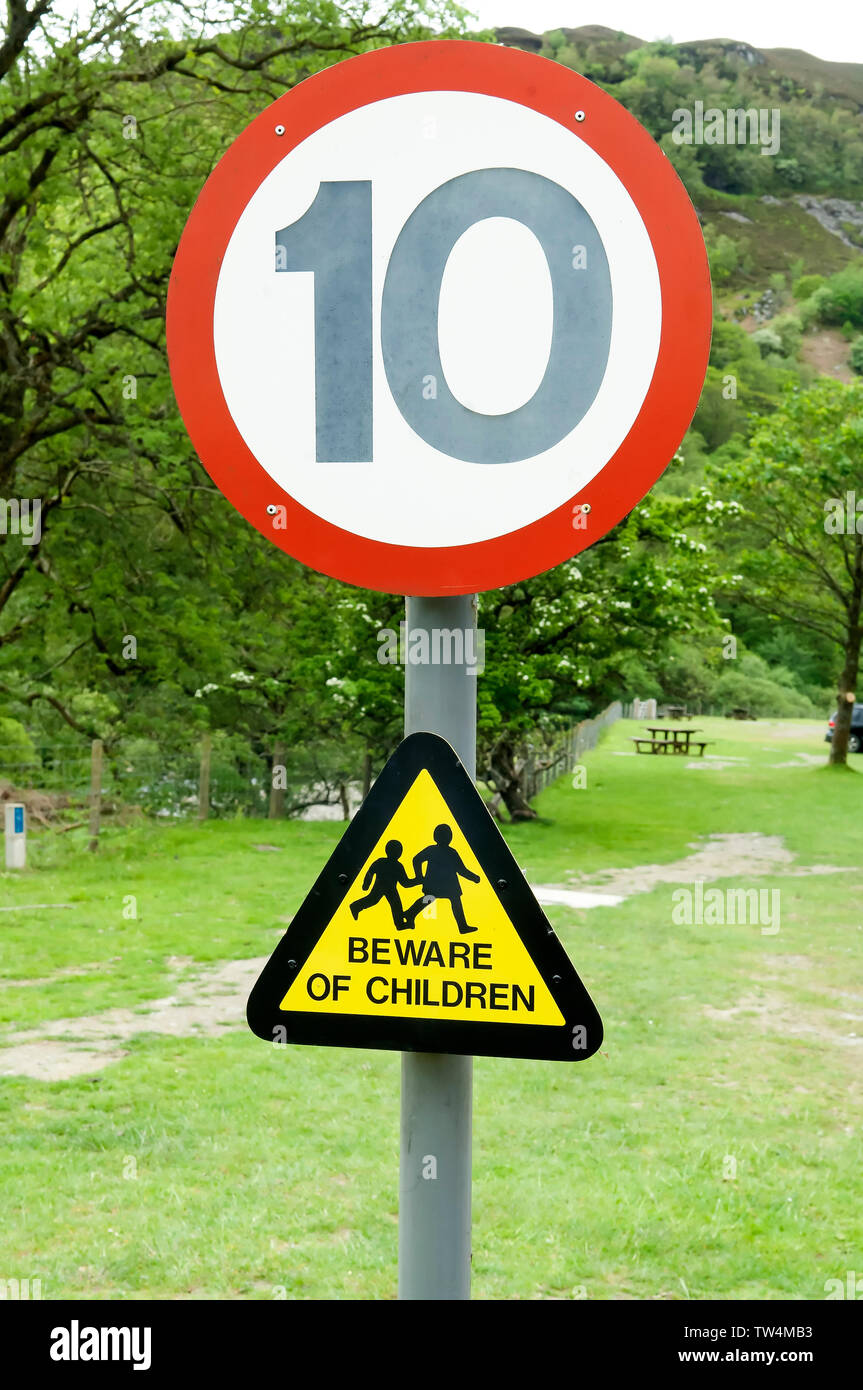 Les pilotes disent signe de se méfier des enfants qui pourraient être dans la route avec une limite de vitesse de 10 milles signer ci-dessus. Banque D'Images