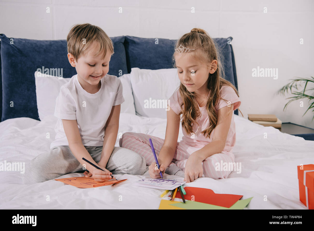 Cute kids accueil fête des pères tout en restant assis sur les voitures à la maison de la literie Banque D'Images