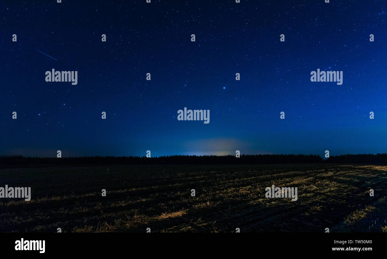 Champ et ciel bleu avec l'étoile au milieu de la nuit Banque D'Images