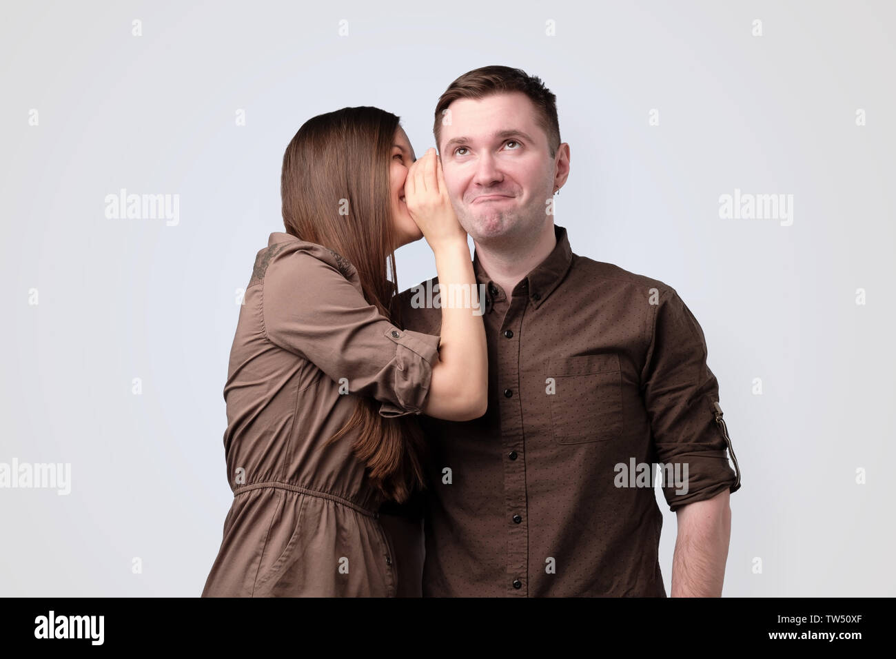 Young woman whispering secret à son petit ami Banque D'Images