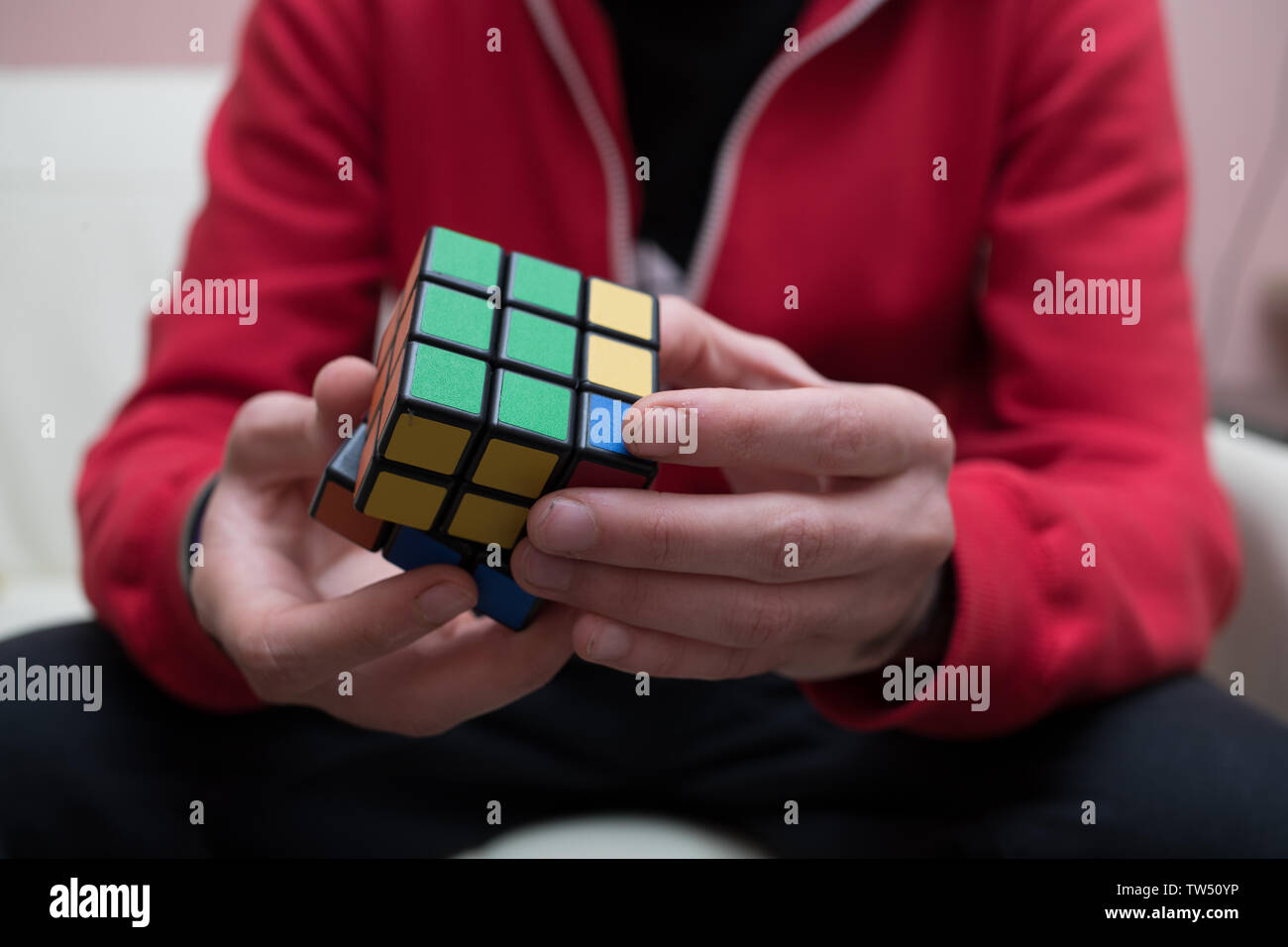 Mains d'un gars recueillir un puzzle cube coloré Banque D'Images