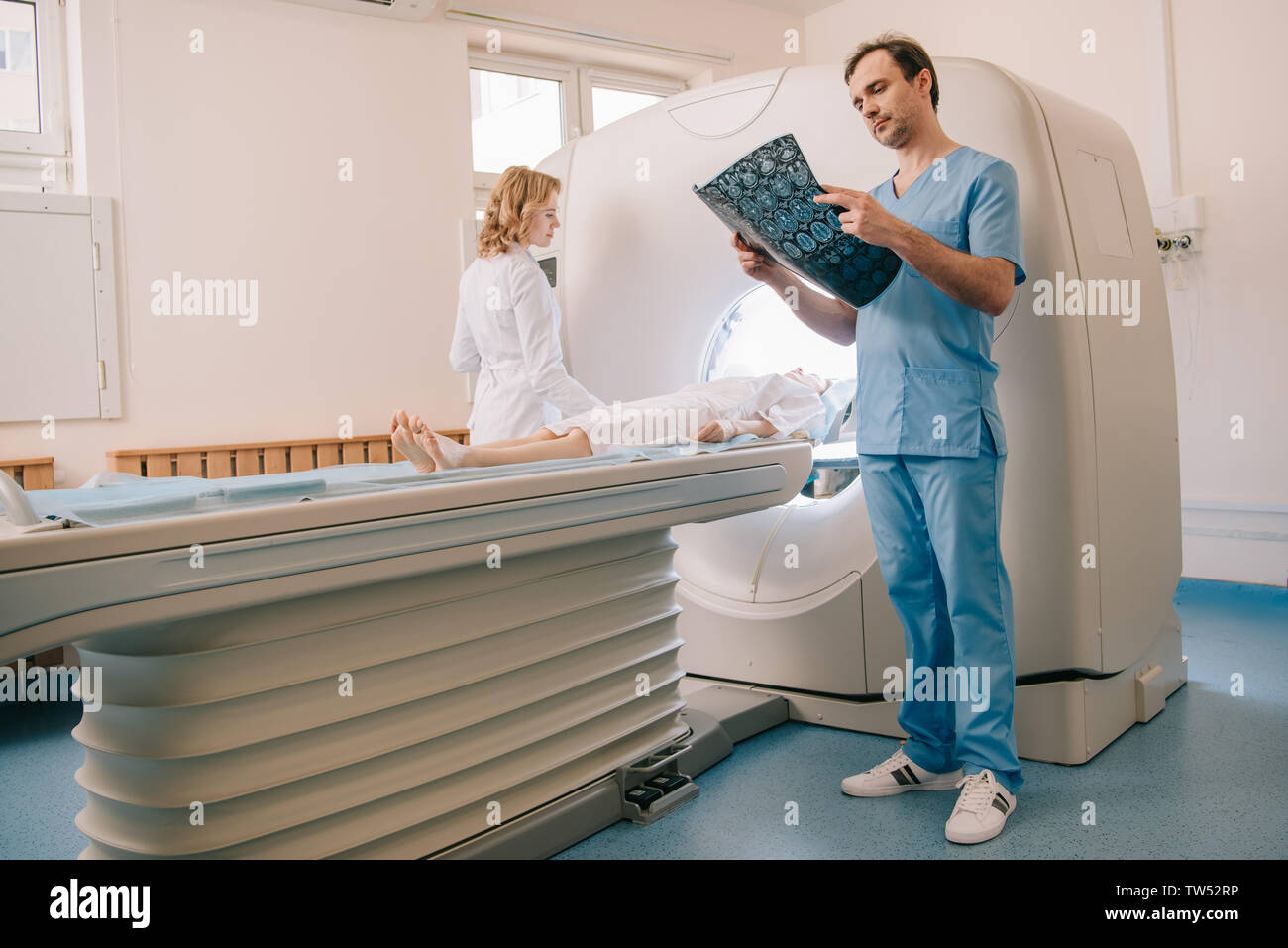 Médecin attentif à la tomographie à tout diagnostic radiologue scanner d'exploitation au cours des diagnostics des patients Banque D'Images