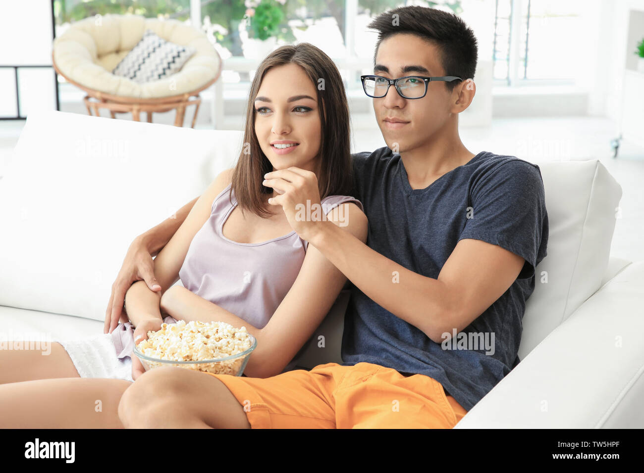 Jeune couple regardant la TV à la maison Banque D'Images