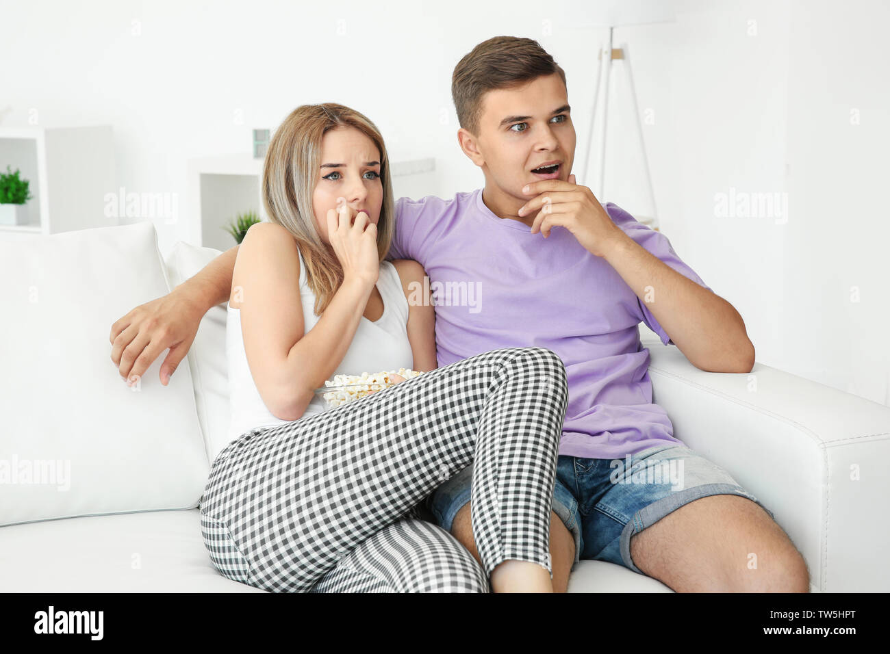 Jeune couple regardant la TV à la maison Banque D'Images