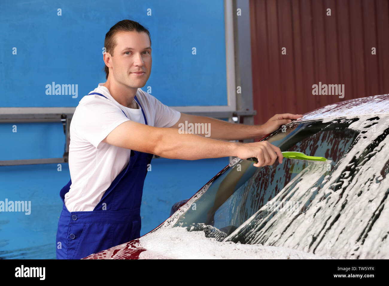 L'homme à la raclette de pare-brise automobile nettoyage au lavage de voiture Banque D'Images