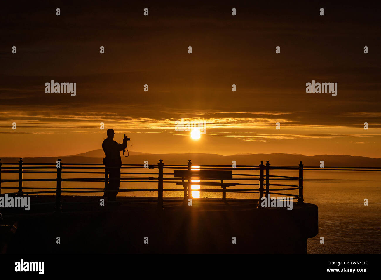 Point de Trafalgar, Morecambe, Lancashire, Royaume-Uni, le 18 juin 2019 visiteurs regardant le coucher du soleil à partir de la fin de la jetée en pierre connu comme point de Trafalgar. Credit : photographier_Nord/Alamy Live News Banque D'Images