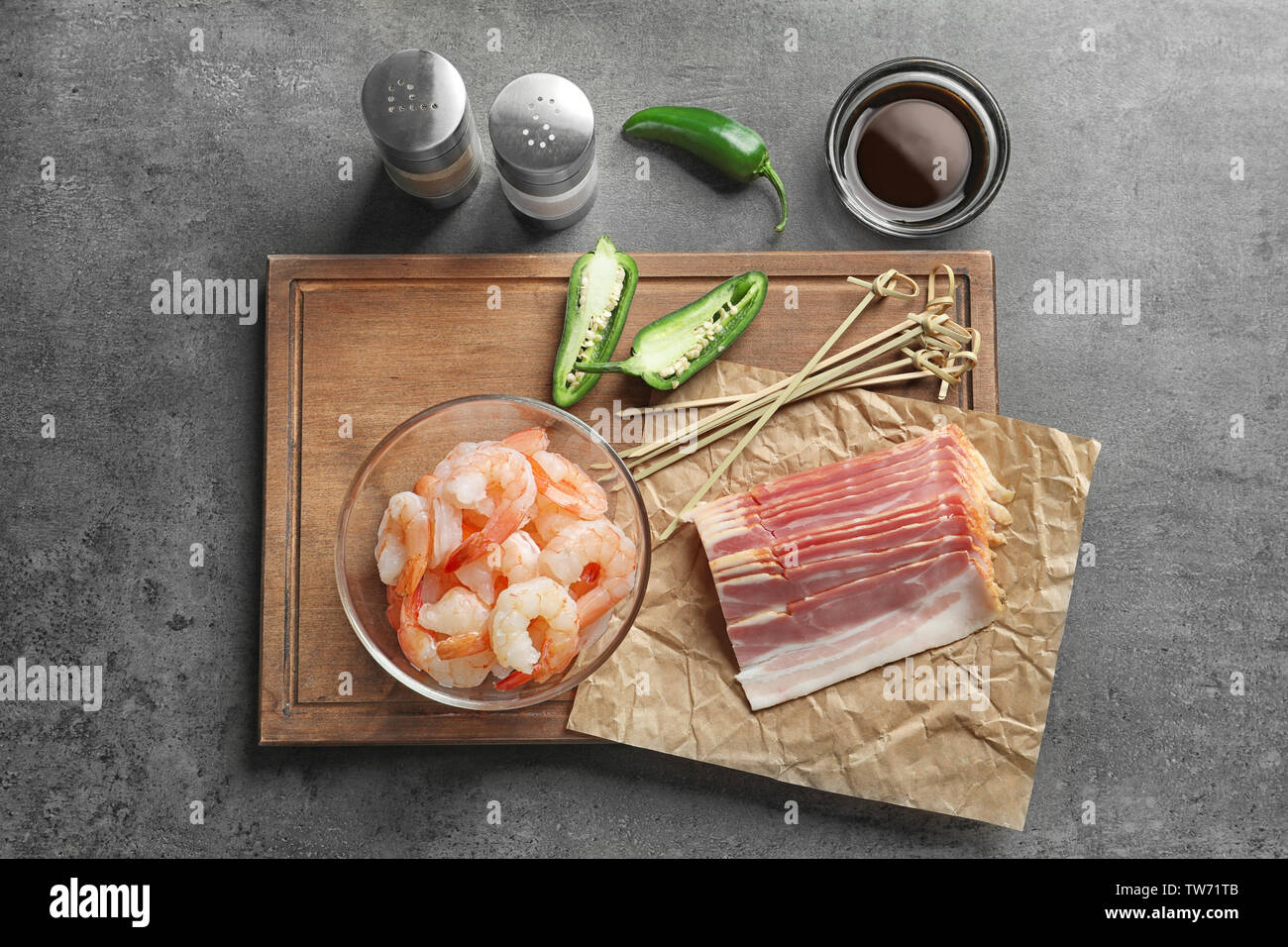 La composition avec crevettes crues et du bacon sur la table Banque D'Images