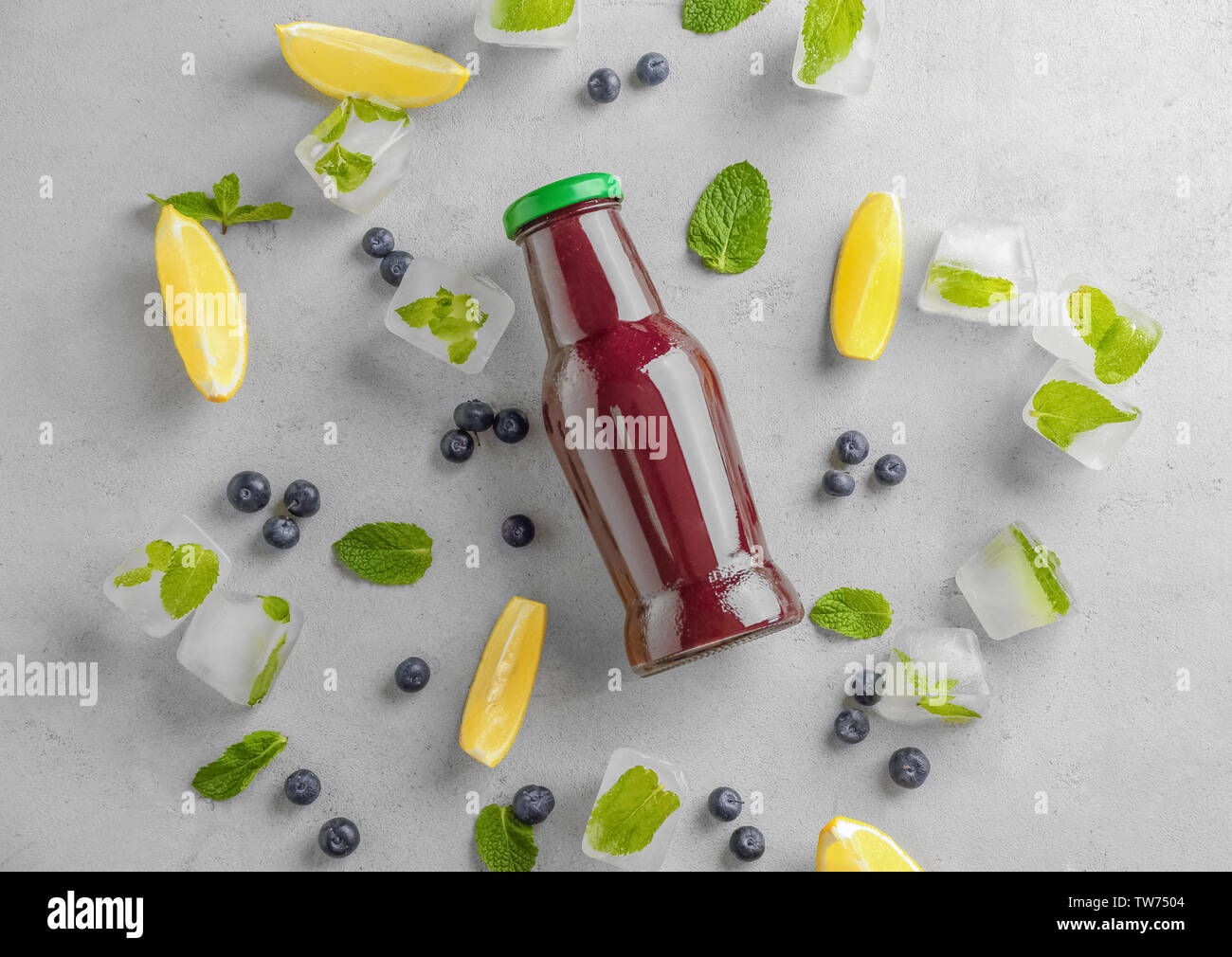 La composition avec l'açaï jus en bouteille de verre sur fond clair Banque D'Images