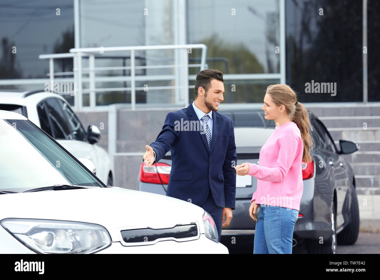 Vendeur montrant nouvelle voiture à l'extérieur du client Banque D'Images