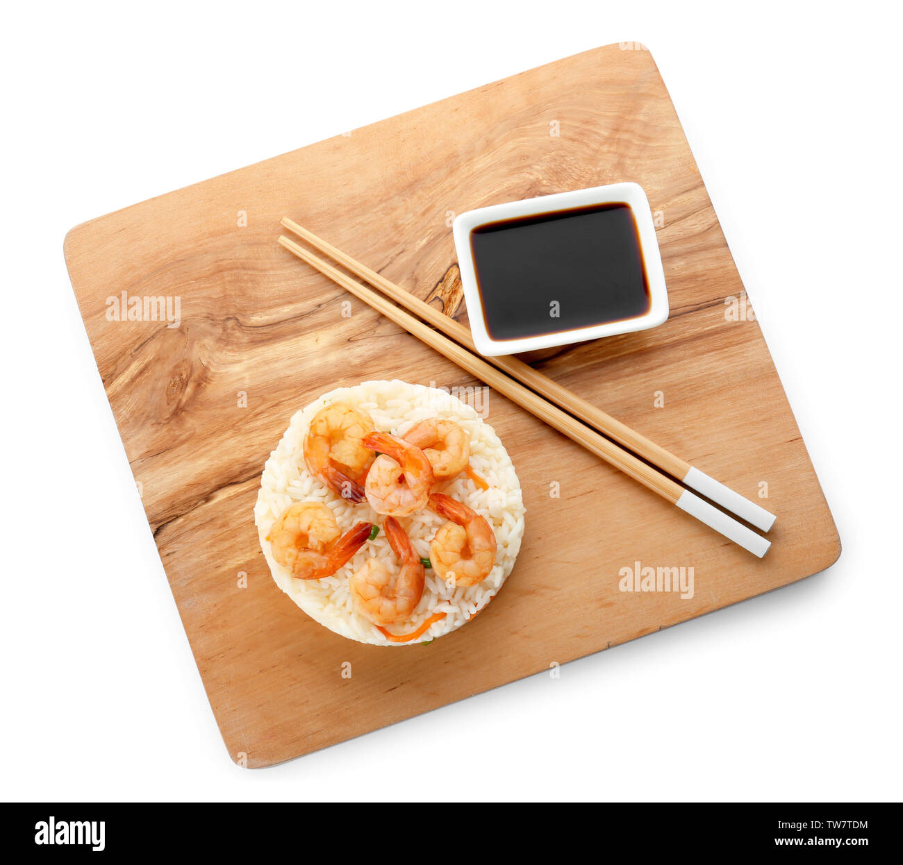 Planche de bois avec de délicieux riz frit aux crevettes sur fond blanc Banque D'Images