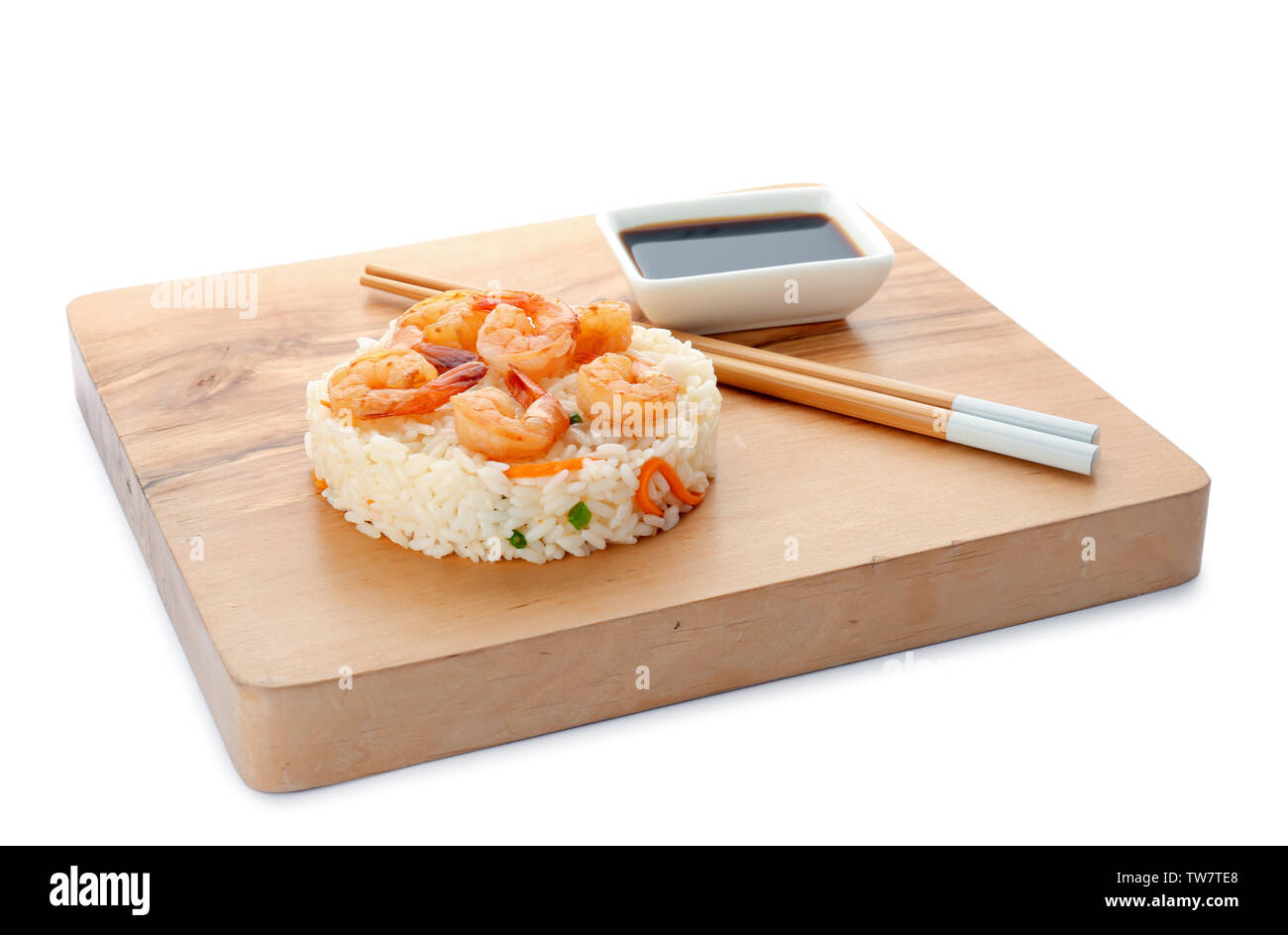 Planche de bois avec de délicieux riz frit aux crevettes sur fond blanc Banque D'Images