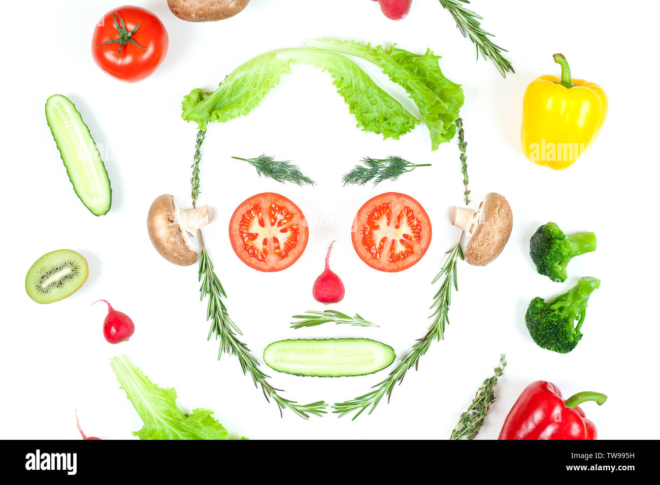Drôle de visage de différents légumes, tomates, concombre, radis, aneth et Rosemary isolé sur fond blanc. La saine alimentation et de la nourriture végétalienne concept Banque D'Images