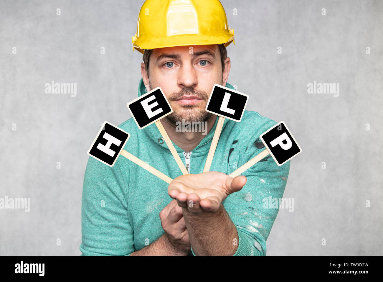Construction Worker holding un tableau noir avec espace pour texte ou texte, copiez l'espace, il demande de l'aide Banque D'Images