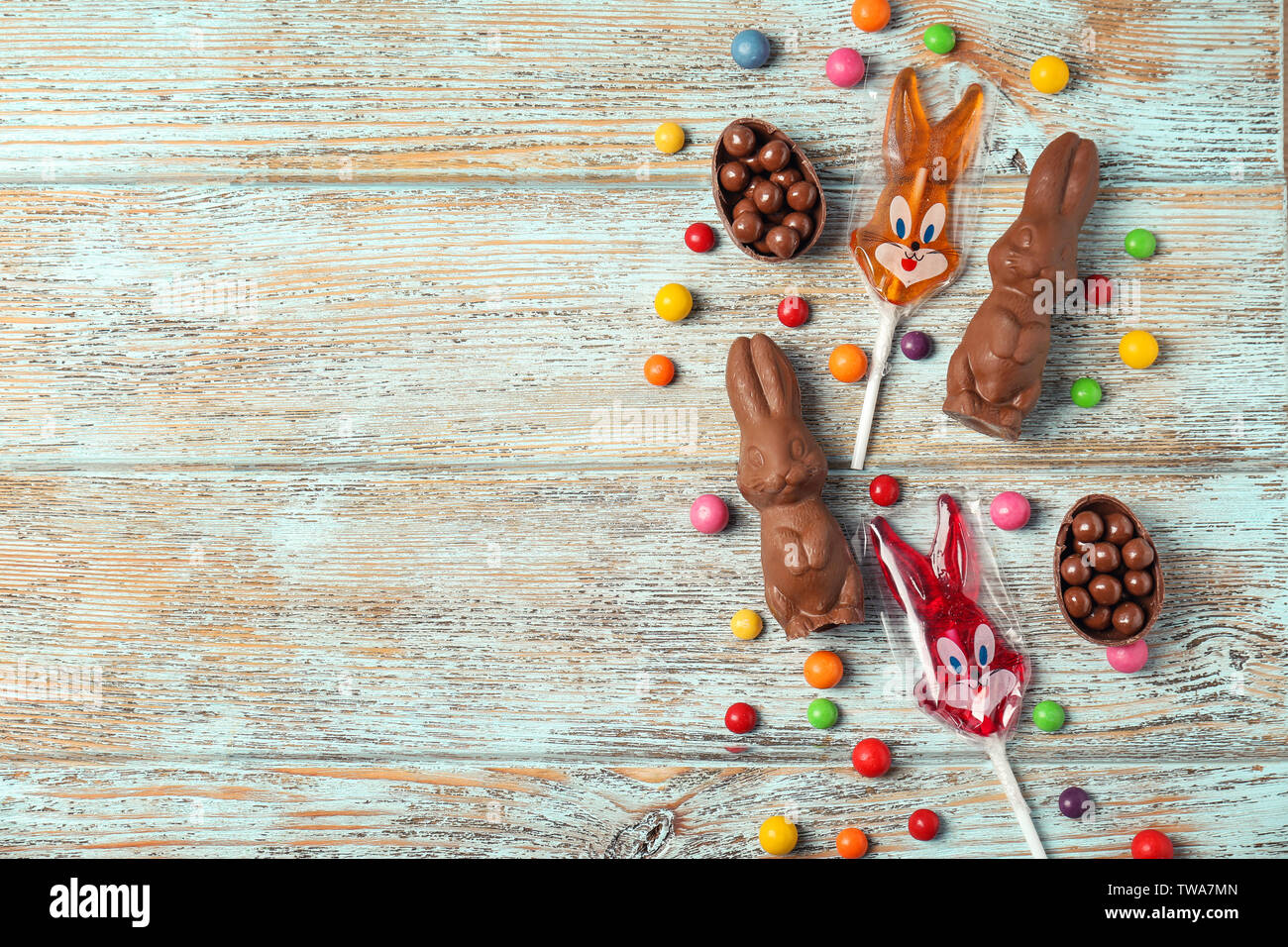 Lapins de Pâques en chocolat et bonbons sur fond de bois Banque D'Images