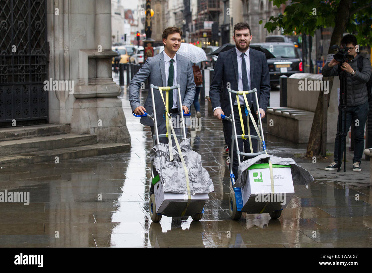 Procureurs greffiers chargés de boîtes de documents juridiques à l'extérieur de la Royal Courts of Justice, Strand, London, England, UK Banque D'Images
