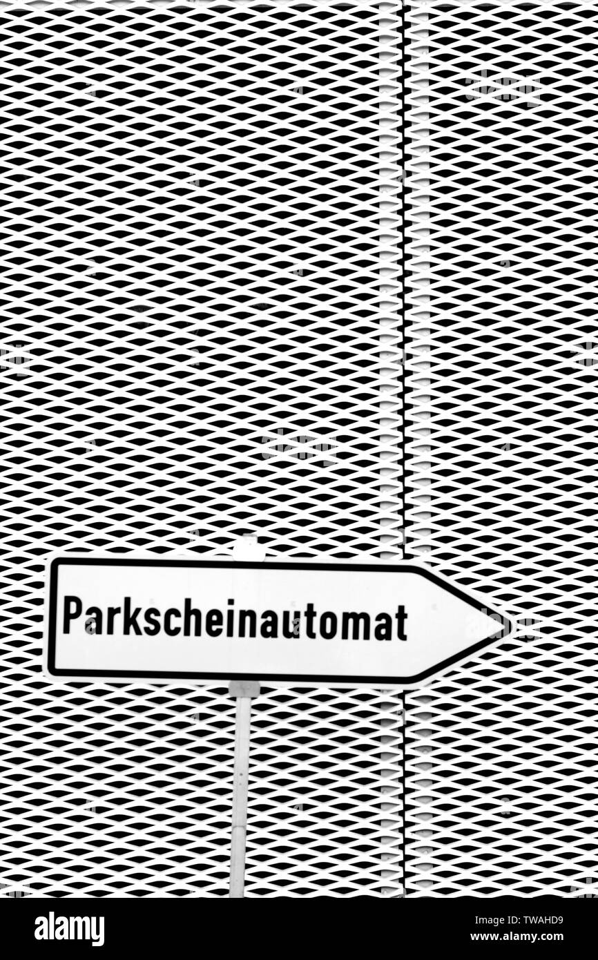 Direction d'un signe indiquant un parking ticket machine en face d'une façade en métal déployé. Banque D'Images