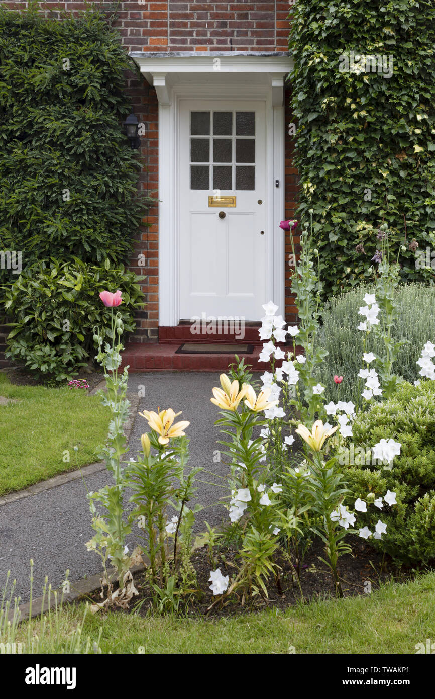 Porte d'une maison typique de la banlieue avec jardin fleuri à Londres, Angleterre Banque D'Images
