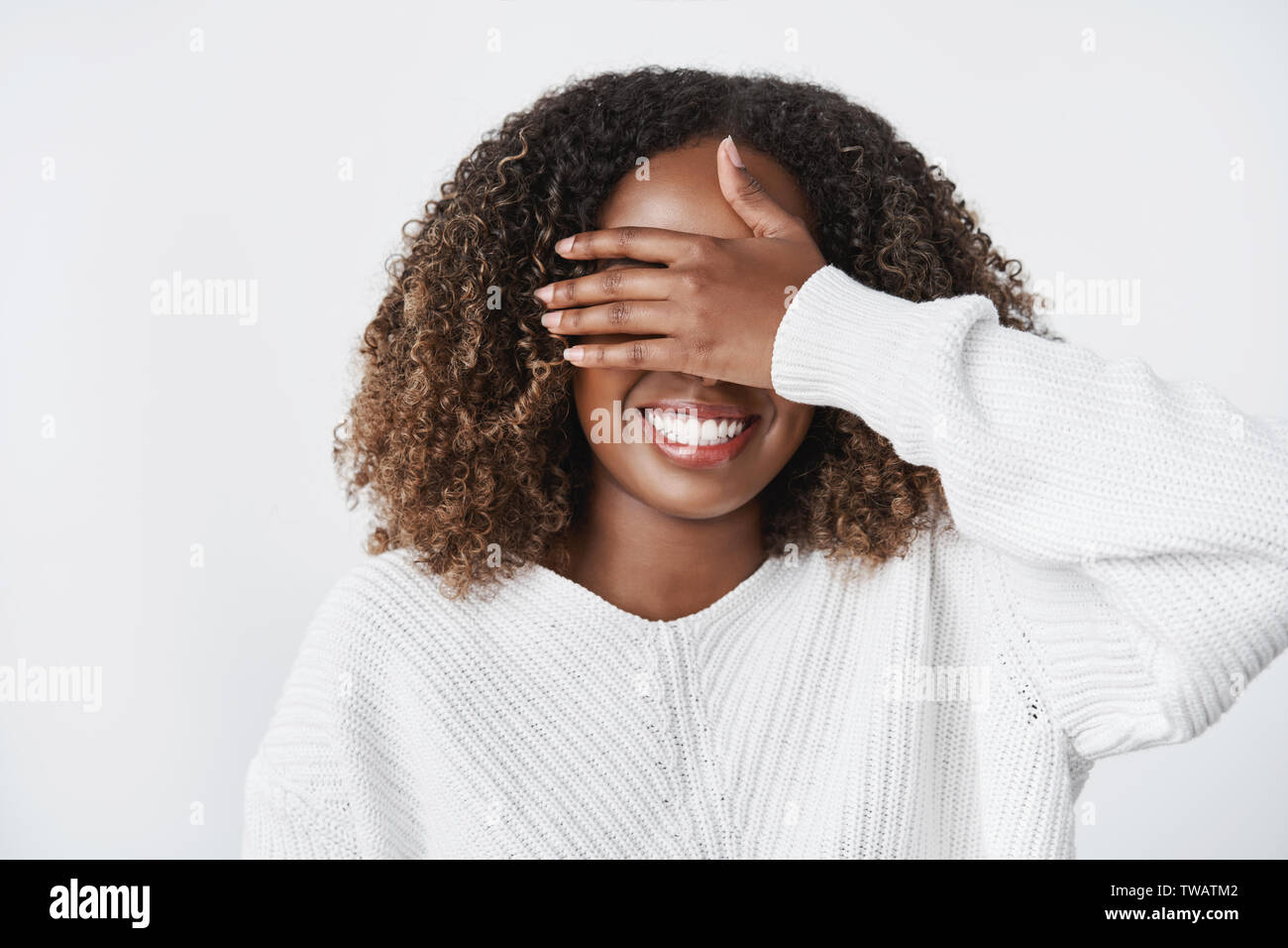 Girl promesse de ne pas fermer les yeux pour attendre peek pour surprise. Charmant heureux et ravis cute african-petite amie américaine près de palmiers et de Banque D'Images