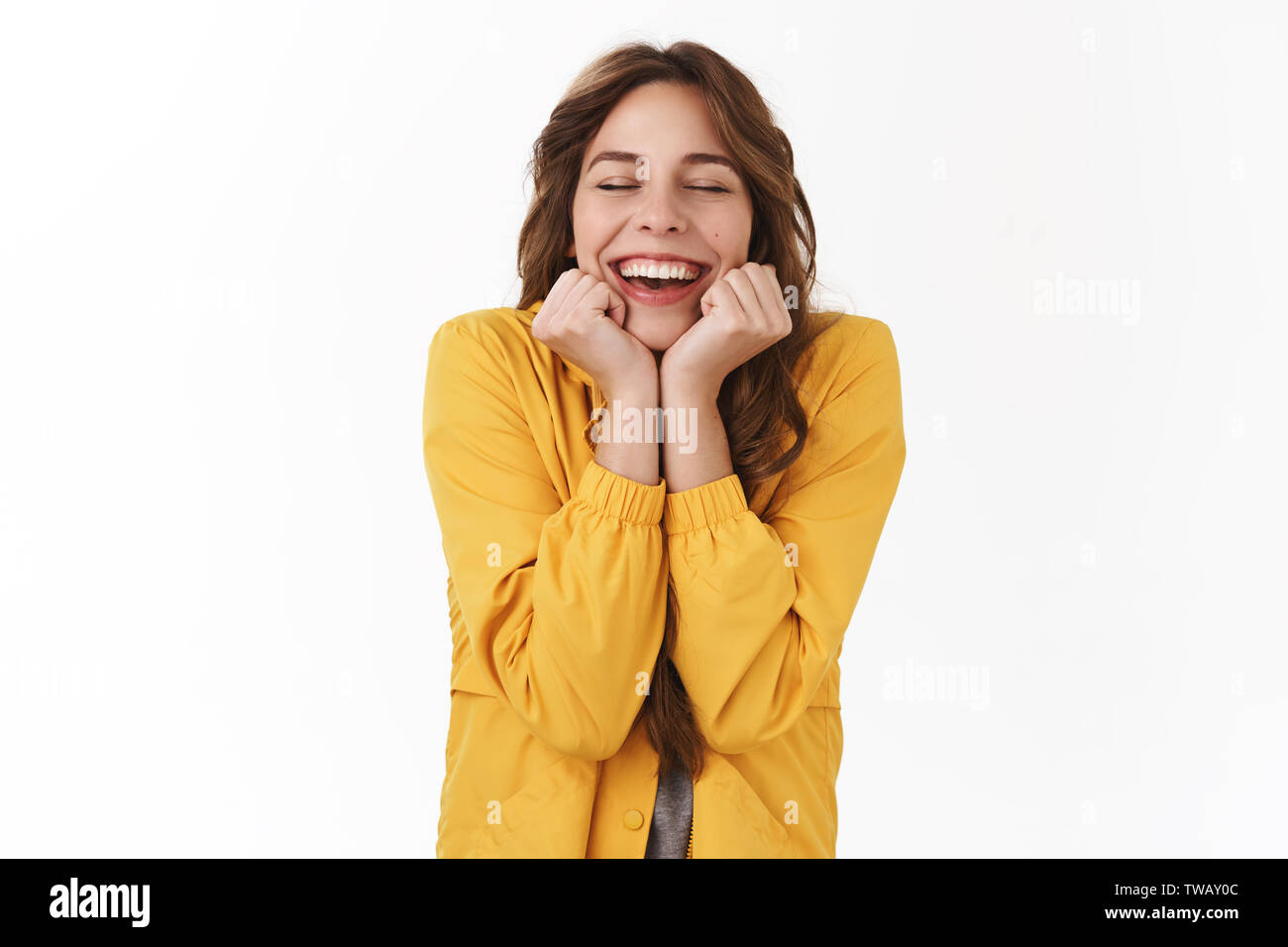 Une nouvelle fantastique me rendent heureux. Cute girl magnifique rêve moderne fermer les yeux souriant joyeusement à pleines dents excité dream est enfin vrai tenir mains visage-line Banque D'Images