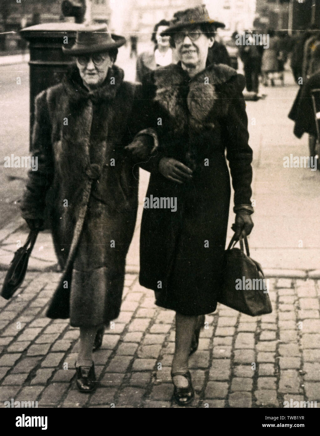 Les vieilles femmes qui marchent en bas de la rue, 1920s Banque D'Images