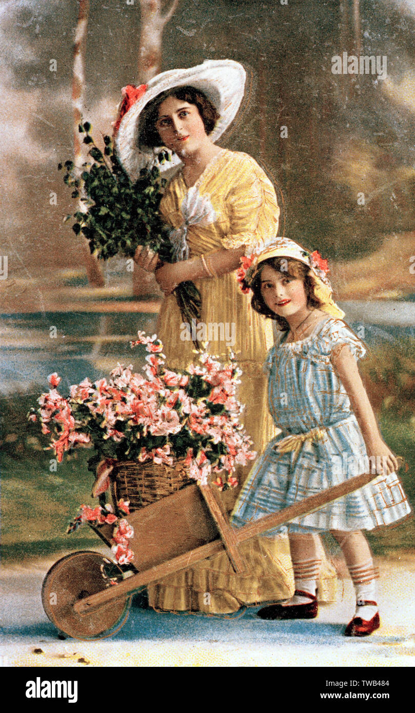 Femme et fille avec des fleurs dans une brouette Banque D'Images