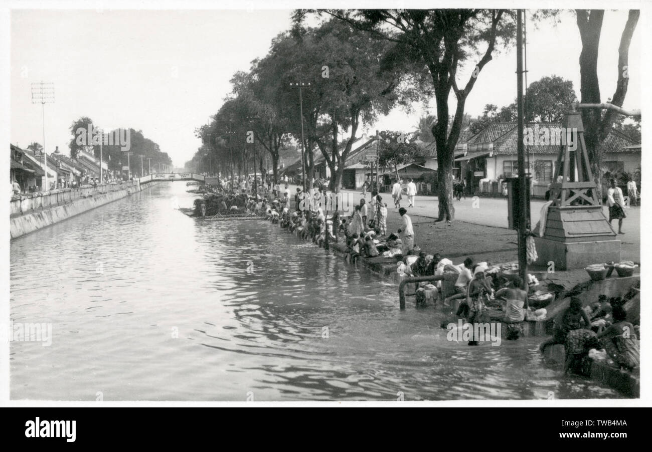 Le canal qui divise Molenvliet Jalan Gajah Mada et Jalan HAYAM WURUK initialement par le capitaine chinois Beng Phoa atau Gam Gam Bing Phoa, second capitaine chinois après Souw Beng Kon. À ce moment, le canal est fait pour transporter le bois de la partie sud de Batavia au les murs de la ville de Batavia. Cette photo montre le canal est utilisé pour la lessive. Date : vers 1930 Banque D'Images