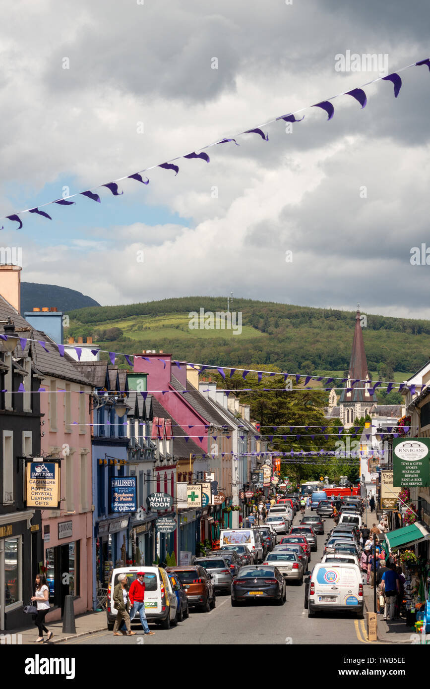 Rue animée petite ville irlandaise Henry Street et l'église Sainte Croix à Kenmare, comté de Kerry, Irlande Banque D'Images