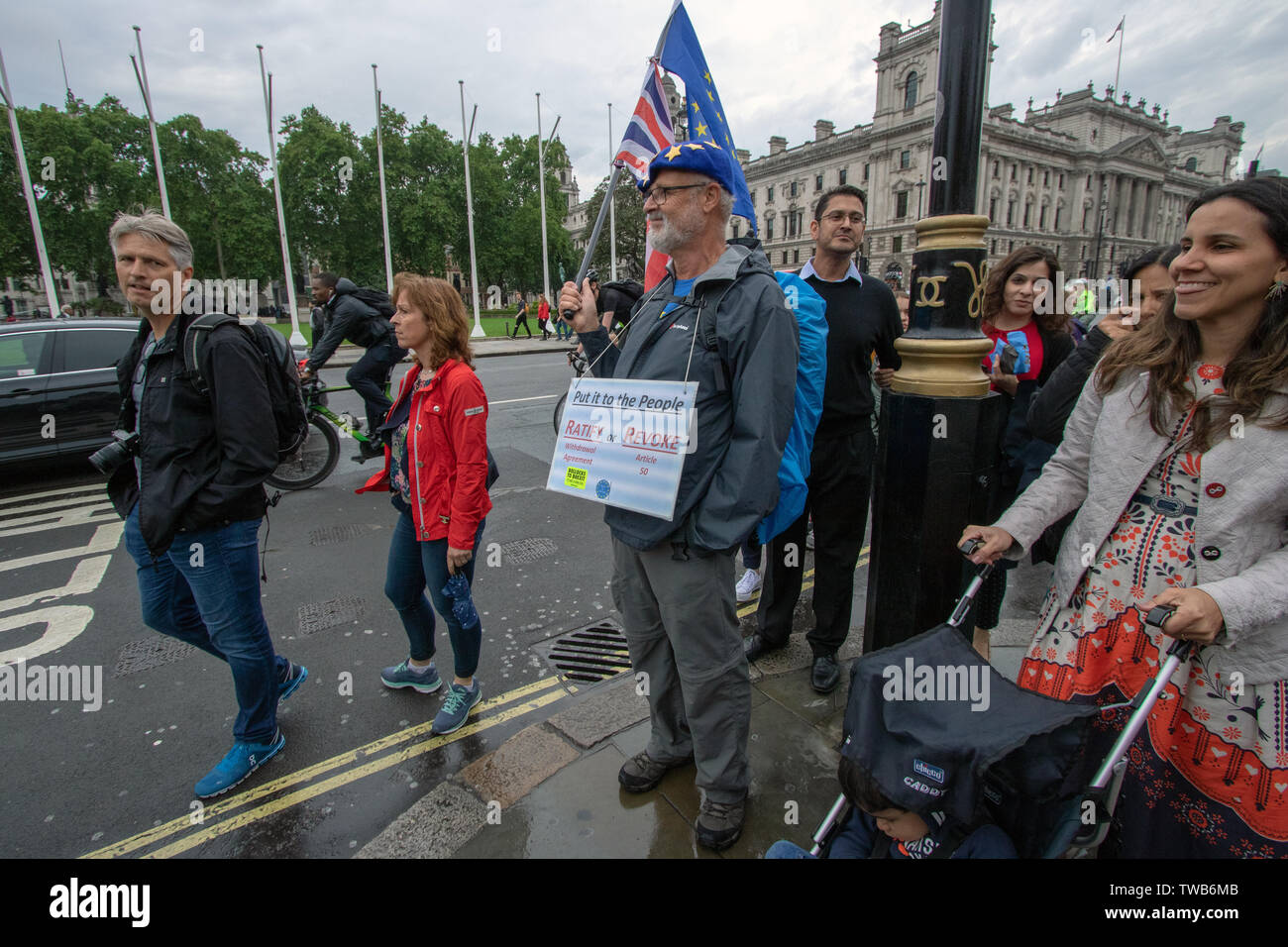Un manifestant avec une plaque-étiquette est titulaire d'un drapeau pendant la manifestation.Anti-Brexiteers ont manifesté devant les Chambres du Parlement, comme un vote pour la direction du parti conservateur a eu lieu. Les manifestants détenus grands drapeaux, pancartes, et crié à pro-Brexit Membres du Parlement. Les coureurs de devenir le prochain premier ministre sont Boris Johnson, Jeremy Hunt, Michael Gove, Rory Stewart, et Sajid Javid, plus tard a pris part à un débat télévisé sur la BBC's New Broadcasting House. Jouer de la musique forte des militants comme les députés ont défilé devant la caméra. Banque D'Images