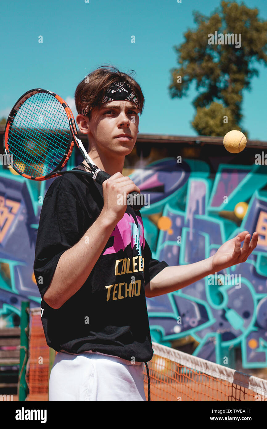 Sport Tennis. L'homme jouant au tennis en plein air. Portrait Of Attractive Young Man In Black T-shirt avec Racket Banque D'Images