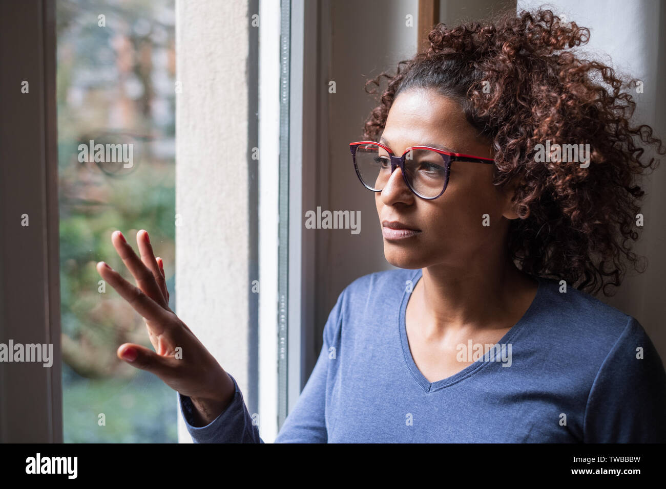 Femme noire solitaire fenêtre près de penser à quelque chose Banque D'Images